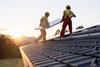 men putting solar panel on roof