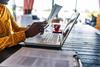 Woman using paper forms to complete survey on laptop