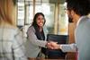 A young woman shakes hands with her interviewer