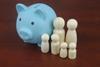 Wooden people figures as members of family with piggy bank and calculator on blue background