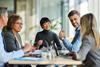 Five people sat around a meeting table
