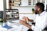 A man speaks to colleagues on a video while hybrid working from home