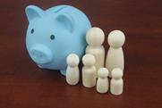 Wooden people figures as members of family with piggy bank and calculator on blue background