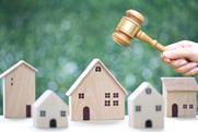 Property auction, Woman hand holding gavel wooden and model house on natural green background