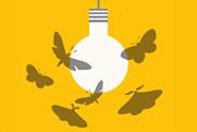 The image shows a minimalist illustration of a white light bulb hanging from a grey cord against a bright yellow background. Several grey moths are flying around the light bulb, attracted to its glow