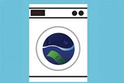 Illustration of a washing machine with a 'CLEAN' message on its digital display. A green banknote is submerged in water inside the drum.