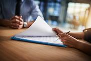 people-completing-paperwork-together-over-desk