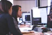 woman using computer with person watching