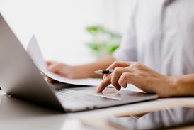 Person sits in front of laptop filling out a form