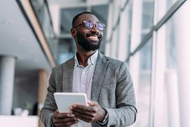 picture of a smiling businessman using a digital tablet in an office setting