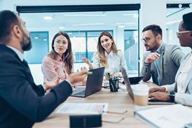 Business people sit around a conference table talking