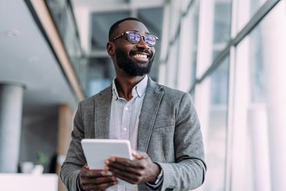 picture of a smiling businessman using a digital tablet in an office setting