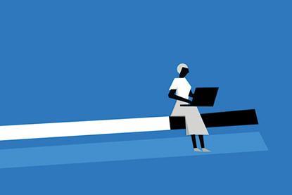 A woman sits at the end of a long bar, looking at her laptop