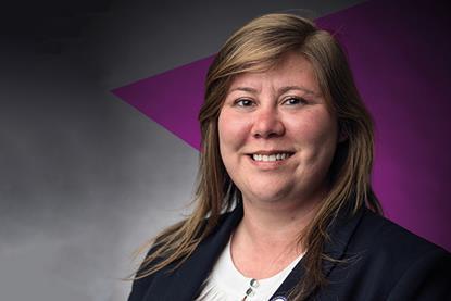 Kayleigh Brown is a white woman with shoulder-length brown hair, she's wearing a dark blazer and smiling. In the background is a dark purple triangle, pointing towards the left