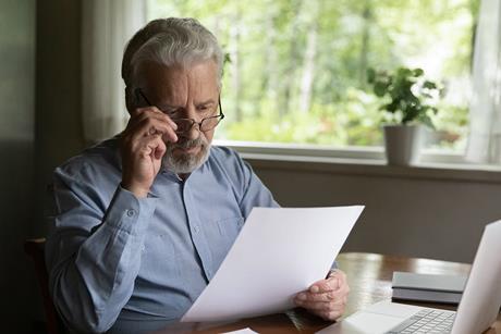 elderly-man-reading-document-drafting-will-1305359960