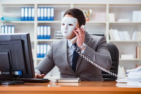 masked man on a phone and computer 1