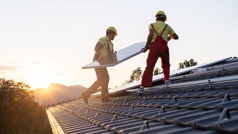 men putting solar panel on roof 