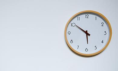 Analogue clock showing ten minutes to six.