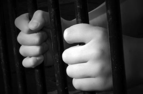 children hands behind bars