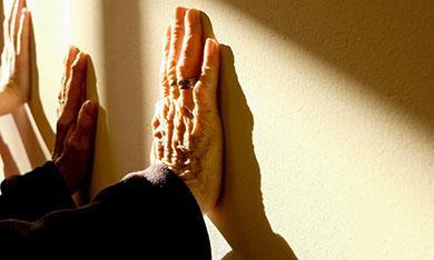 Elderly clients hands against wall